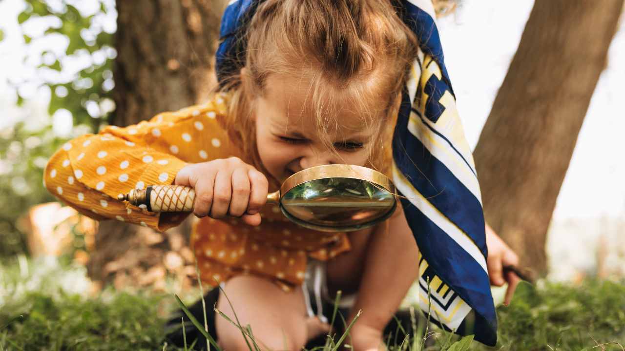 Bambini con una lente di ingrandimento nel bosco durante una vacanza