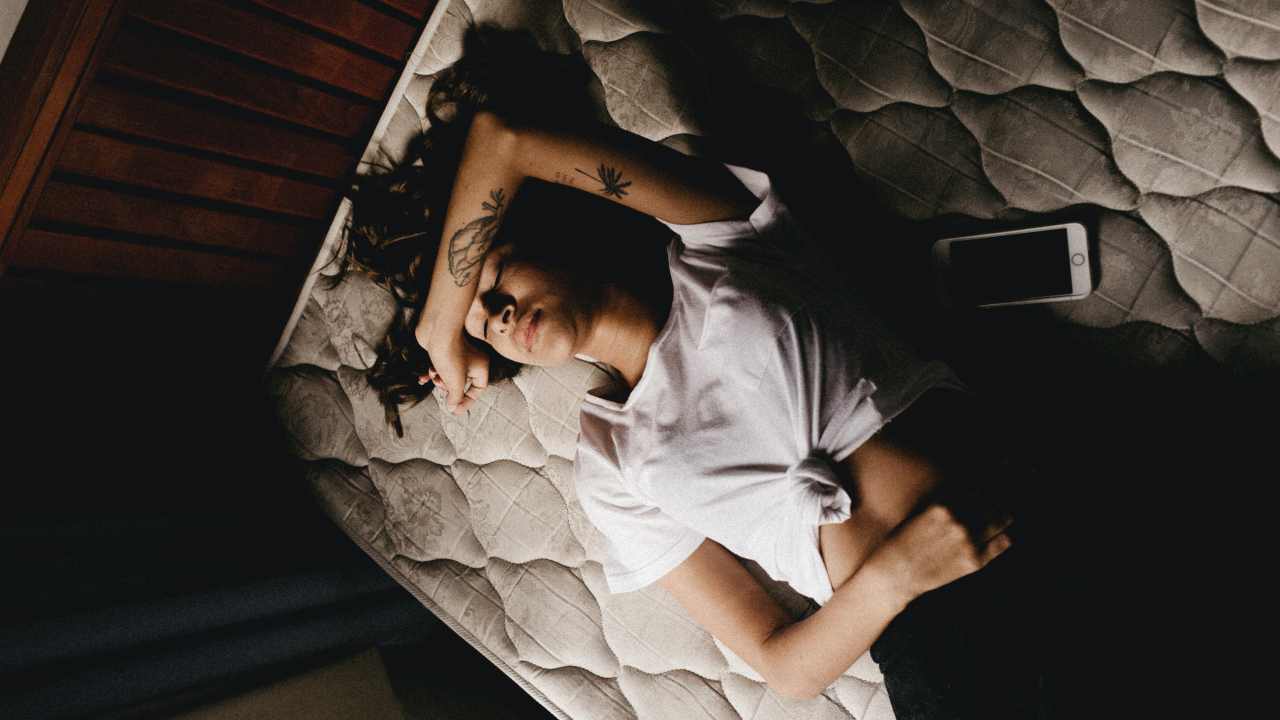 Donna sdraiata sul letto con dolori mestruali